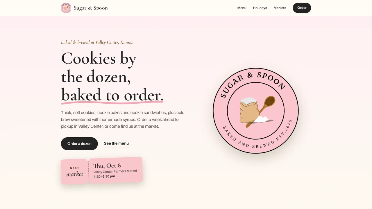 The Sugar & Spoon homepage: the line 'Baked & brewed in Valley Center, Kansas', the headline 'Cookies by the dozen, baked to order.', an Order a dozen button, a pink ticket showing the next market date, and the bakery's round pink logo
